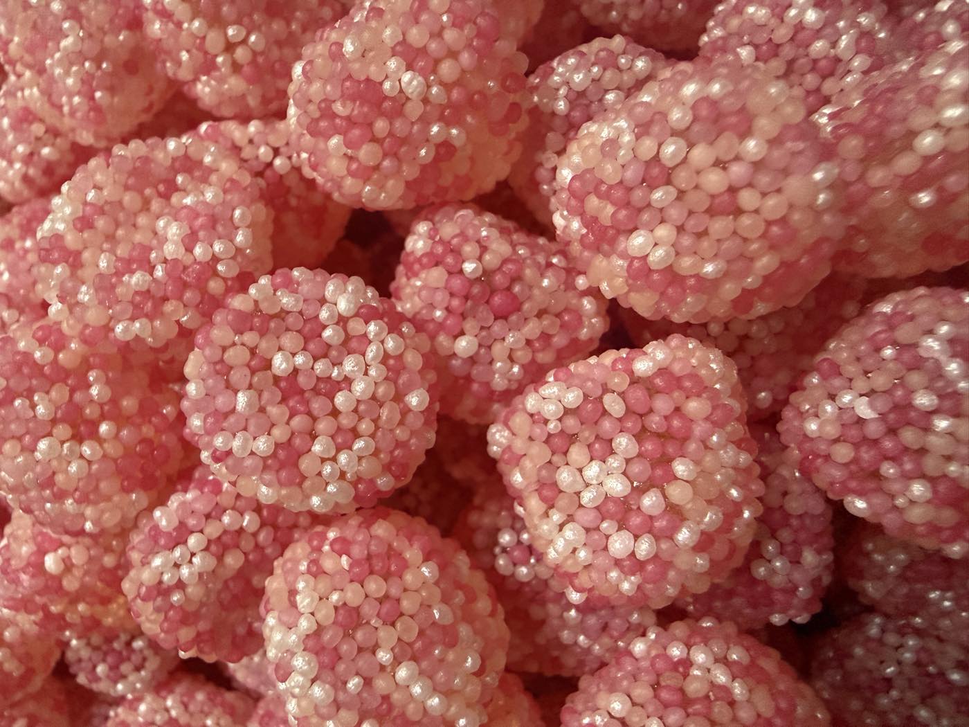 A close-up of pink sugared berry sweets