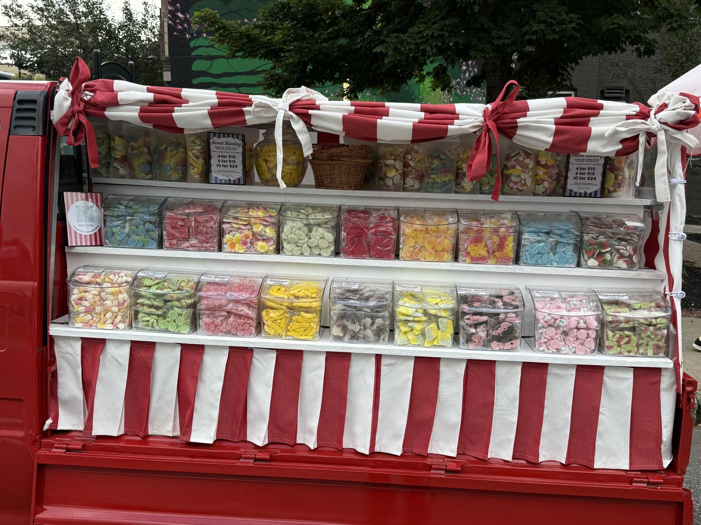The candy shelves close up, jars lined along the striped valance